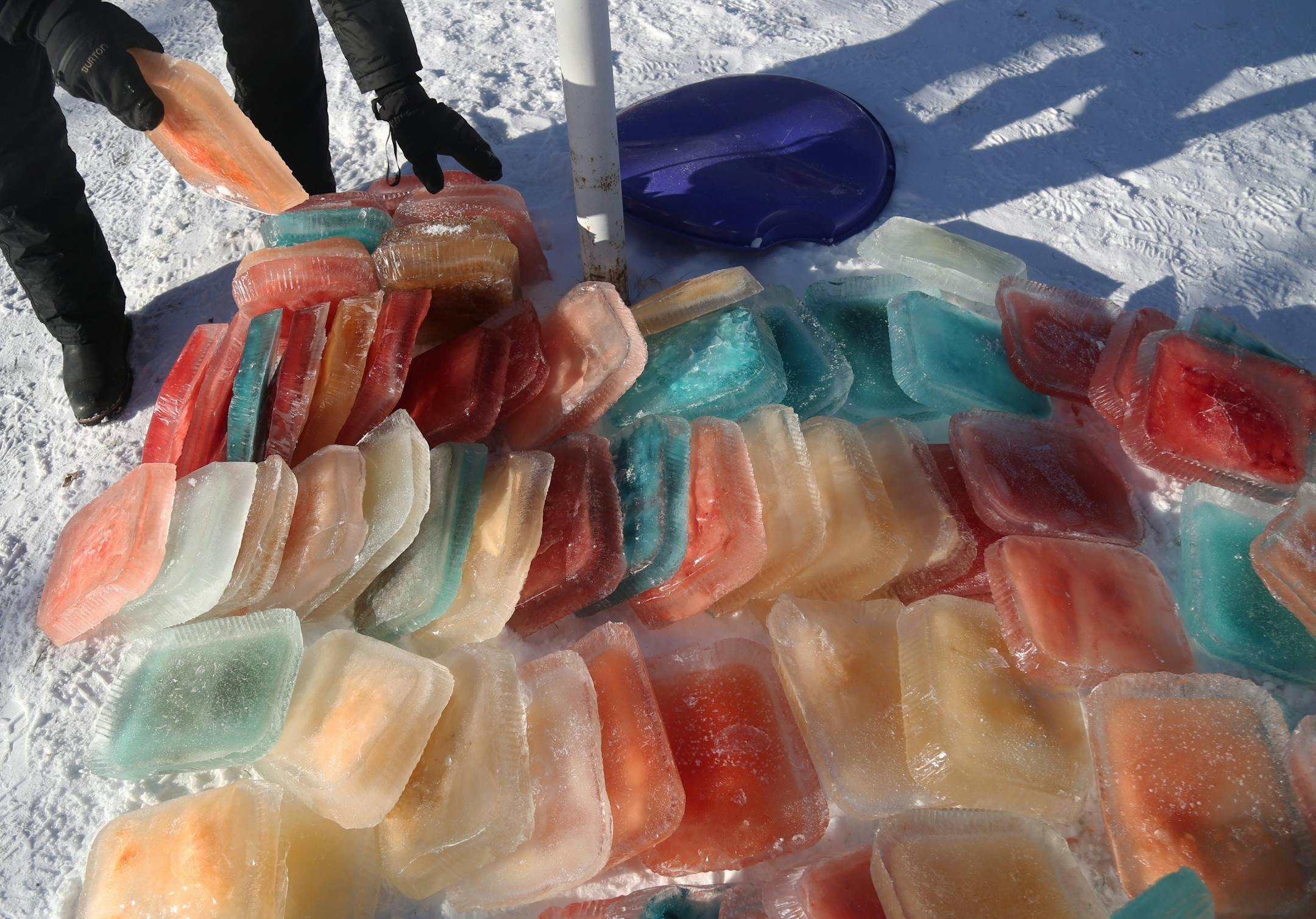Martha Palm, her family and some former students of hers will be working on the multi-colored igloo they are building at the Palms' south Minneapolis home and seen Saturday, Dec. 30, 2017, in Minneapolis, MN. Here, a pile of multi-colored ice blocks sit in a pile to be used in building the igloo.