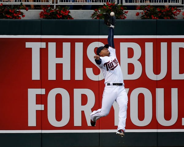 Twins Eduardo Escobar reached back to make the catch of Cubs Miguel Montero fly ball during the fourth inning.