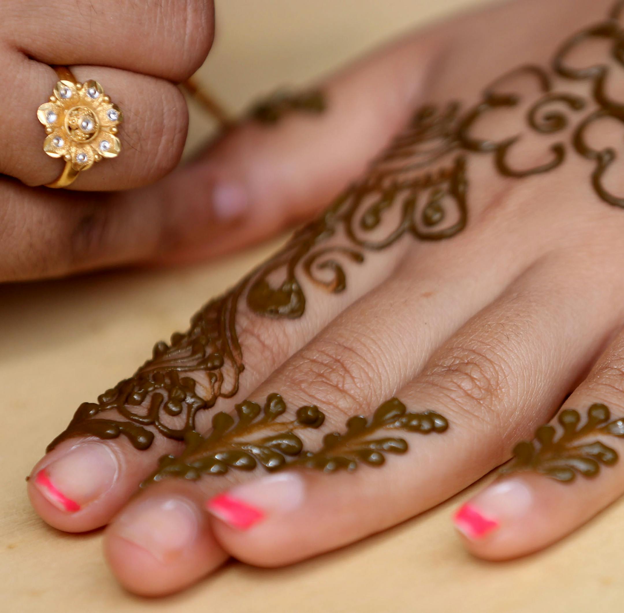 Henna artist Tahera Sattuwala, of St. Anthony, worked on a design for Rinkal Barekh, of Apple Valley, as other waited in line. ] (KYNDELL HARKNESS/STAR TRIBUNE) kyndell.harkness@startribune.com ndia Fest, an annual celebration of Minnesota's 40,000 South Asian Indian residents. Gov. Mark Dayton, who attended, proclaimed it "India Fest Day." in St. Paul Min,. Saturday, August, 16, 2014.