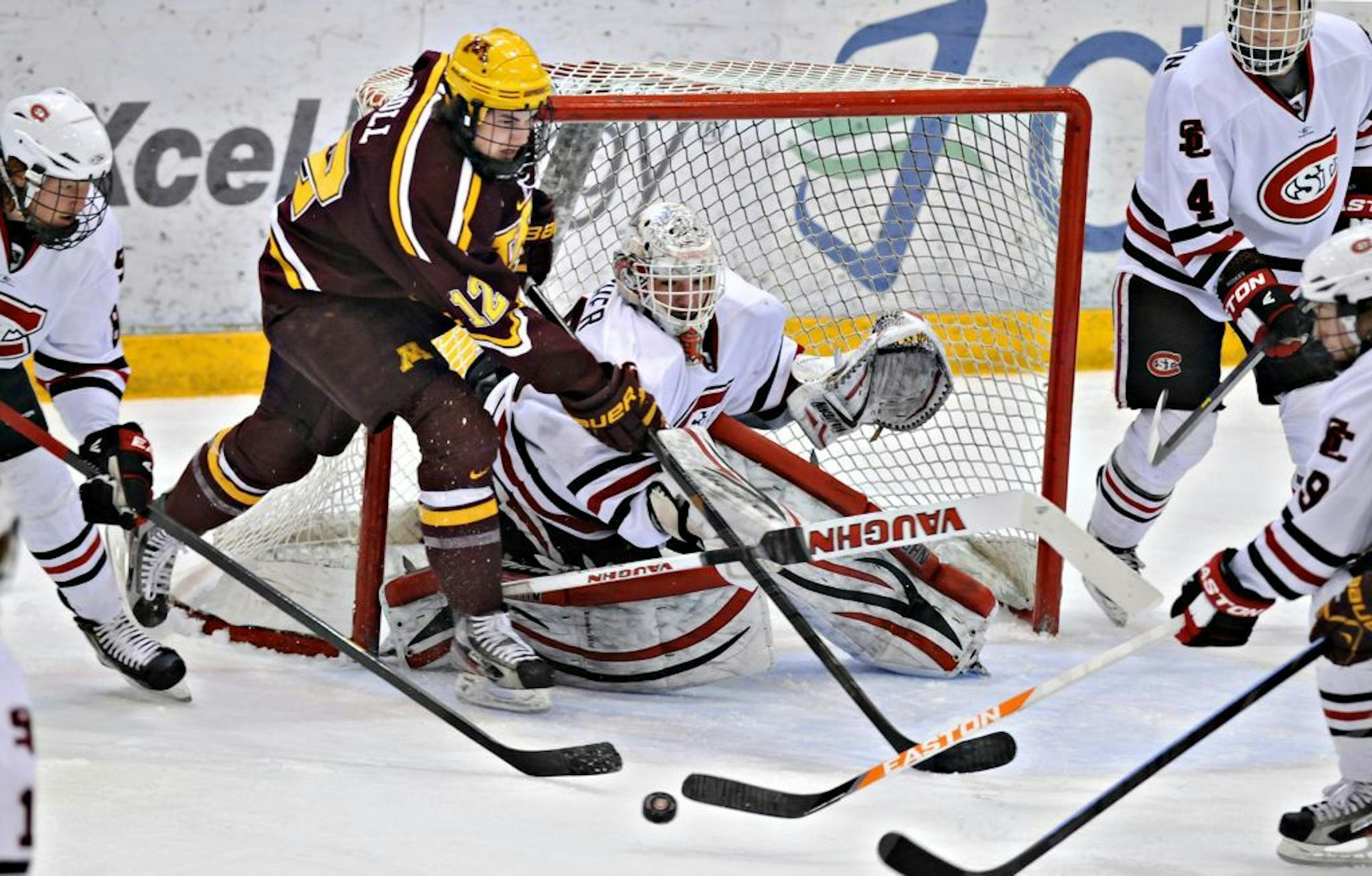 Minnesota's Justin Holl tries to get a shot on St. Cloud State goaltender Ryan Faragher.