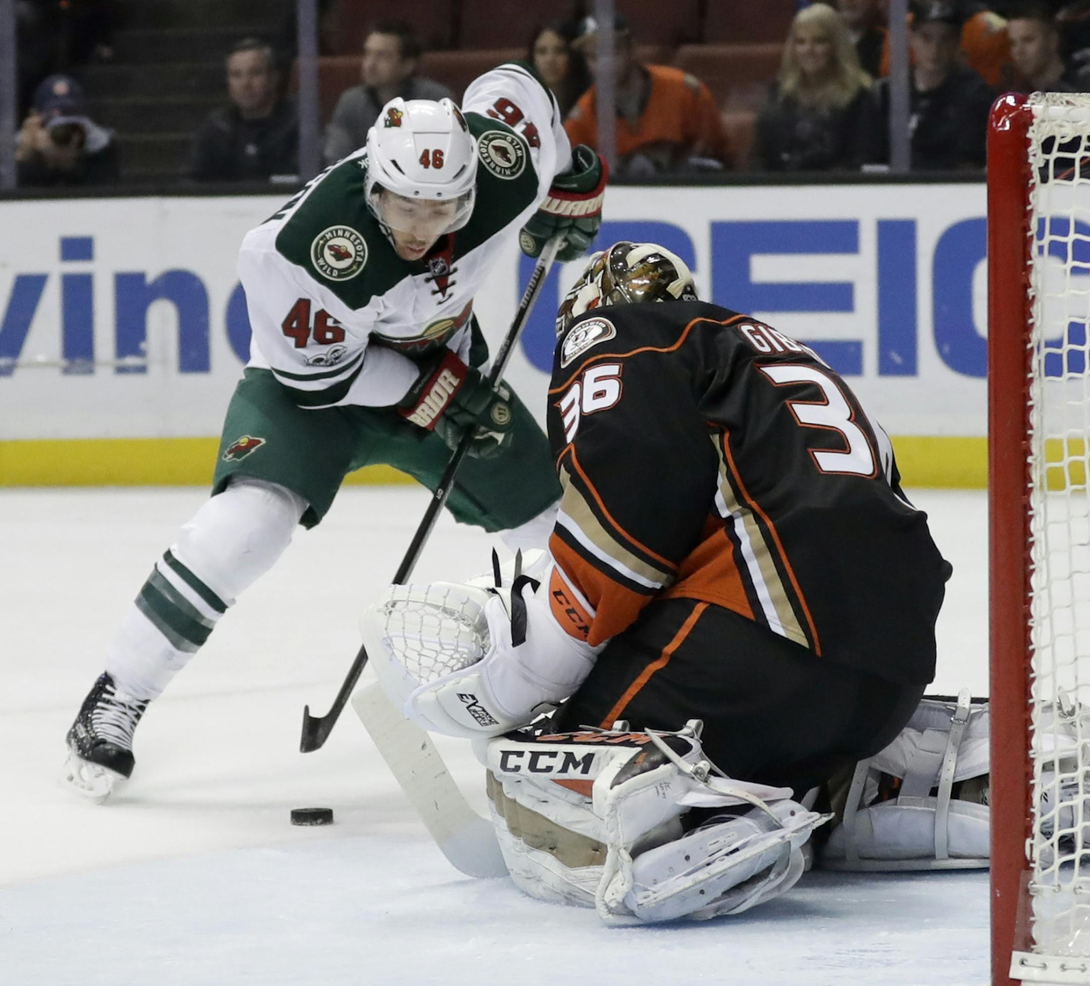 Anaheim Ducks goalie John Gibson, right, blocks a shot by Minnesota Wild defenseman Jared Spurgeon during the first period of an NHL hockey game in Anaheim, Calif., Sunday, Jan. 8, 2017.