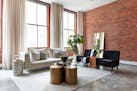 A leaning mirror is placed against a brick wall in an industrial-style loft living space. (Scott Gabriel Morris/Handout/TNS)