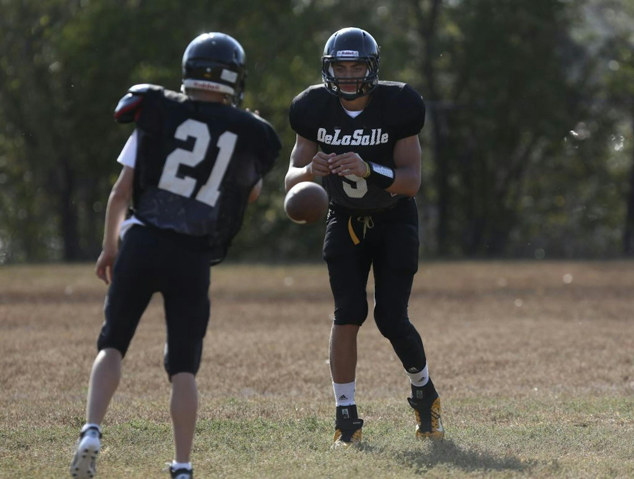 Quarterback Reid Travis took snaps as he worked on passing during DeLasalle's practice at Marshall Terrace field in Minneapolis, Min., Tuesday September 11, 2012.