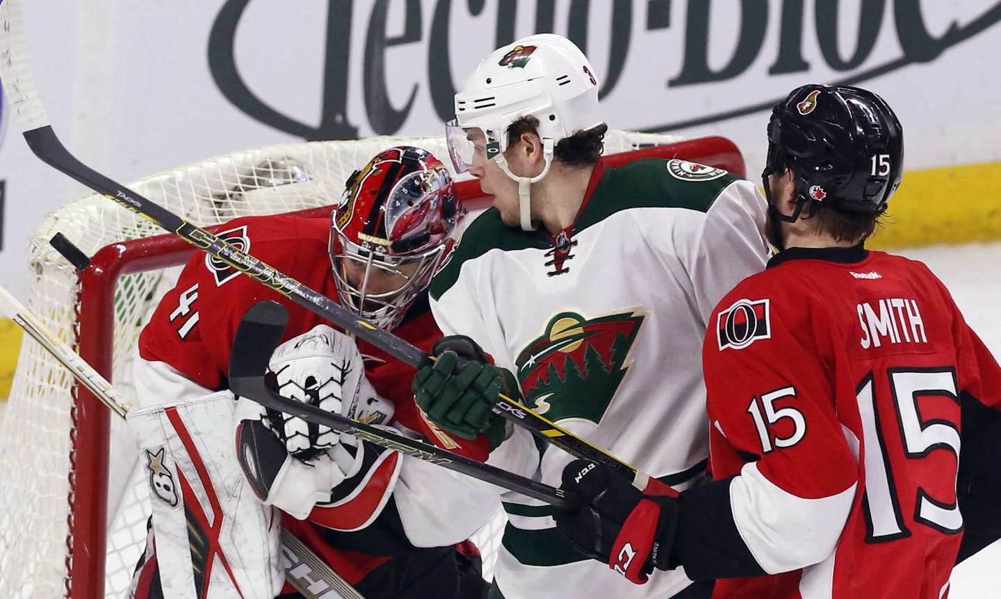 Minnesota Wild's Charlie Coyle, middle, and Ottawa Senators goaltender Craig Anderson (41) watch a loose puck as Senators' Zak Smith (15) defends during the second period of an NHL hockey game Tuesday, March 15, 2016, in Ottawa, Ontario. (Fred Chartrand/The Canadian Press via AP)