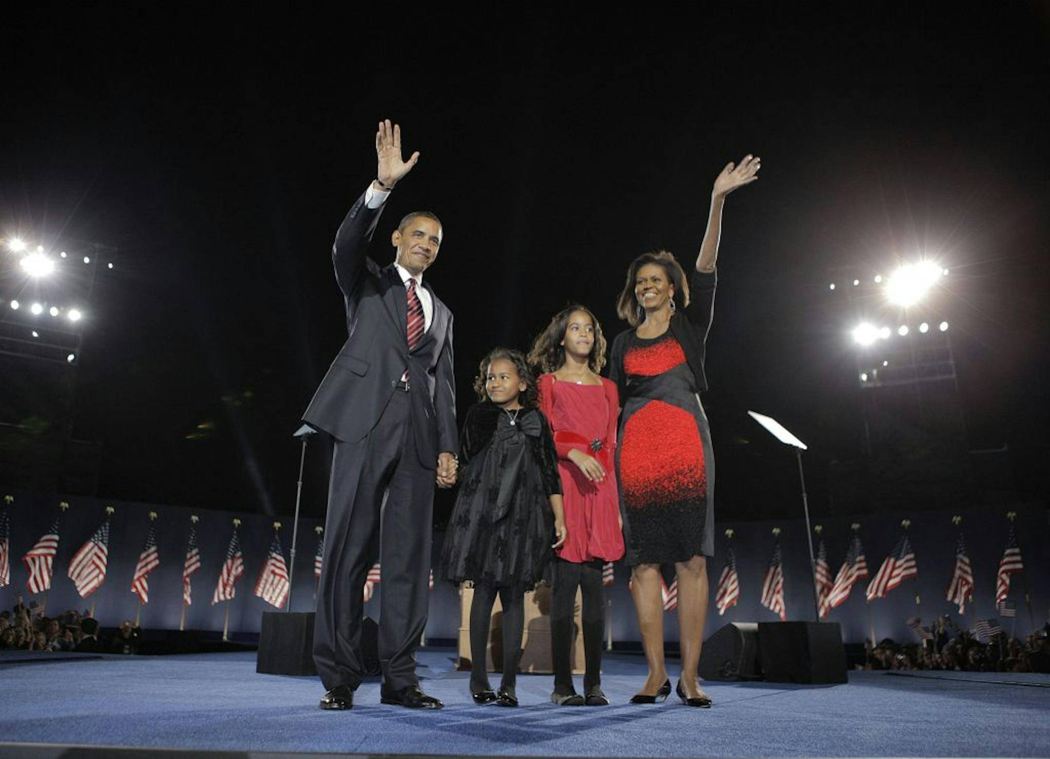 President-elect Barack Obama, left, his wife Michelle Obama, right, and two daughters, Malia, 7, and Sasha, 10, wave at the election night rally in Chicago, Tuesday, Nov. 4, 2008.