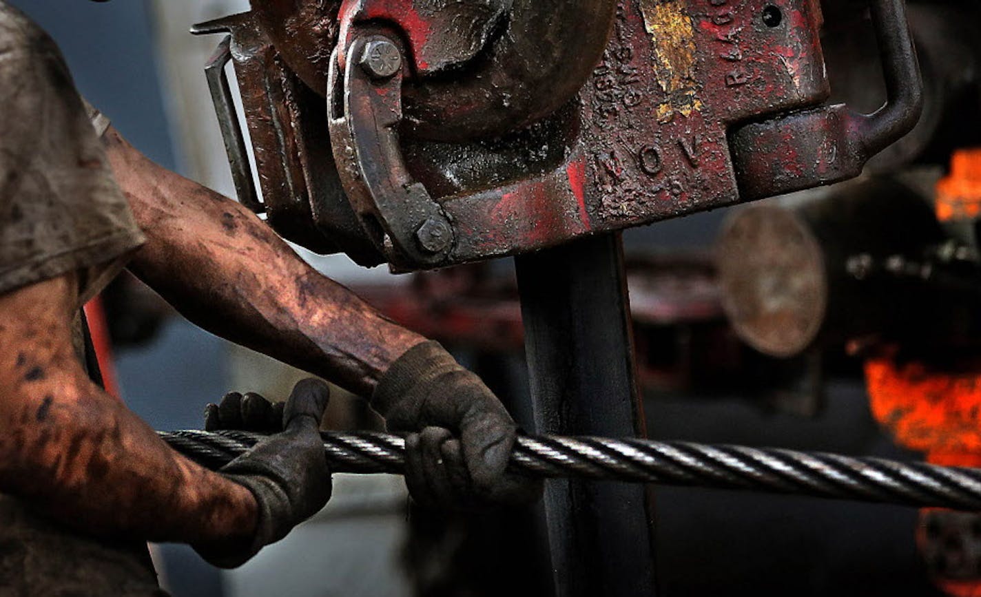 Floor hand Ray Gerrish worked to make repairs on a drilling rig as the sun rose near the site outside Watford City. ] (JIM GEHRZ/STAR TRIBUNE) / October 23, 2013, Keene, ND &#x201a;&#xc4;&#xec; BACKGROUND INFORMATION- PHOTOS FOR USE IN SECOND PART OF NORTH DAKOTA OIL BOOM PROJECT: Dozens of drilling rigs dot the North Dakota landscape in the Williston Basin and the Bakken Oil Formation. Once the rigs drill holes, several miles deep and then several miles horizontally, hydraulic fracturing techno