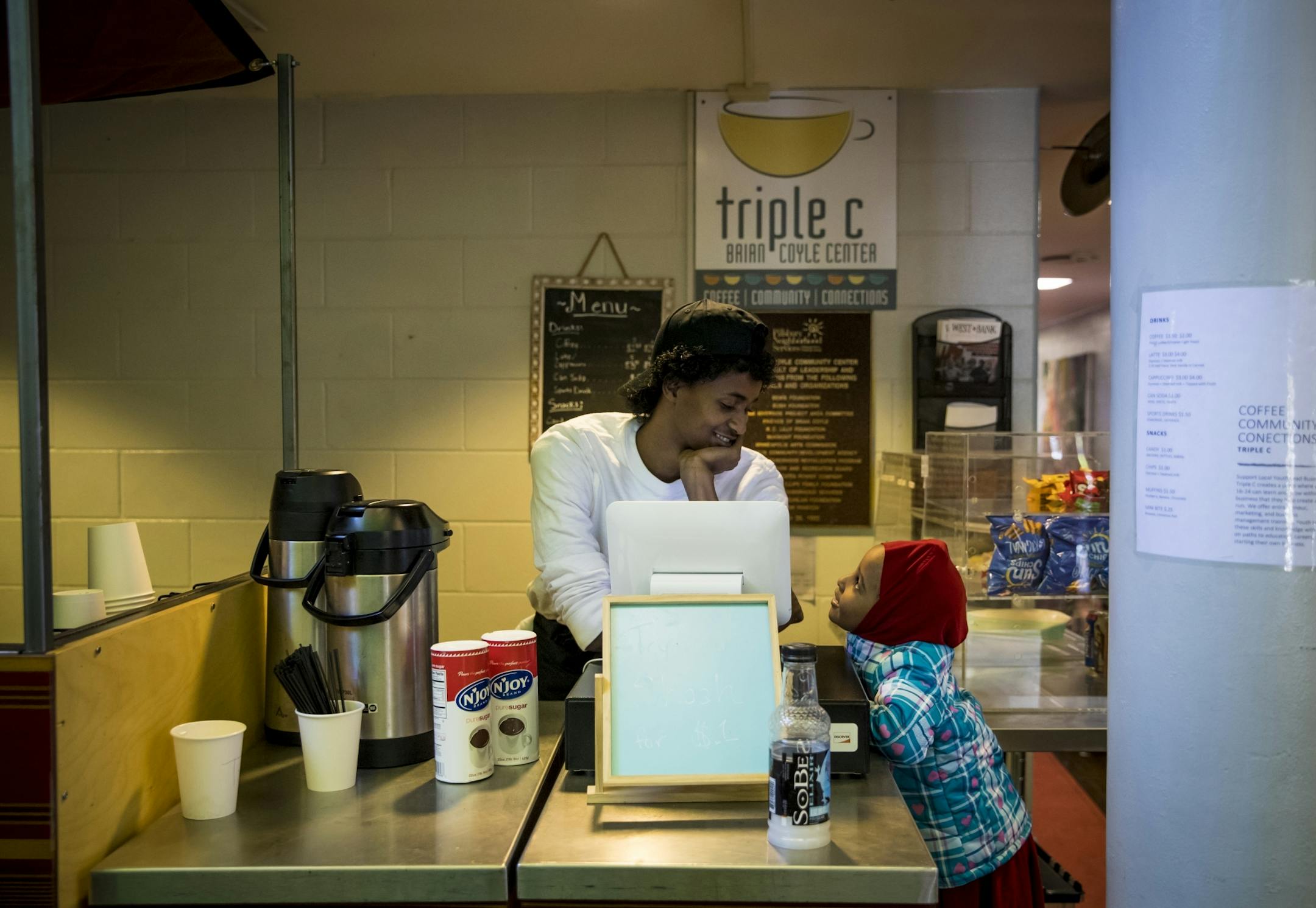 Abdulkadir Hassan chatted with four-year-old Aish Ahmed as he worked at the Triple C coffee shot at the Brian Coyle Center on Monday, October 24, 2016, in Minneapolis, Minn. Aish was waiting with her mom to see someone about childcare assistance.