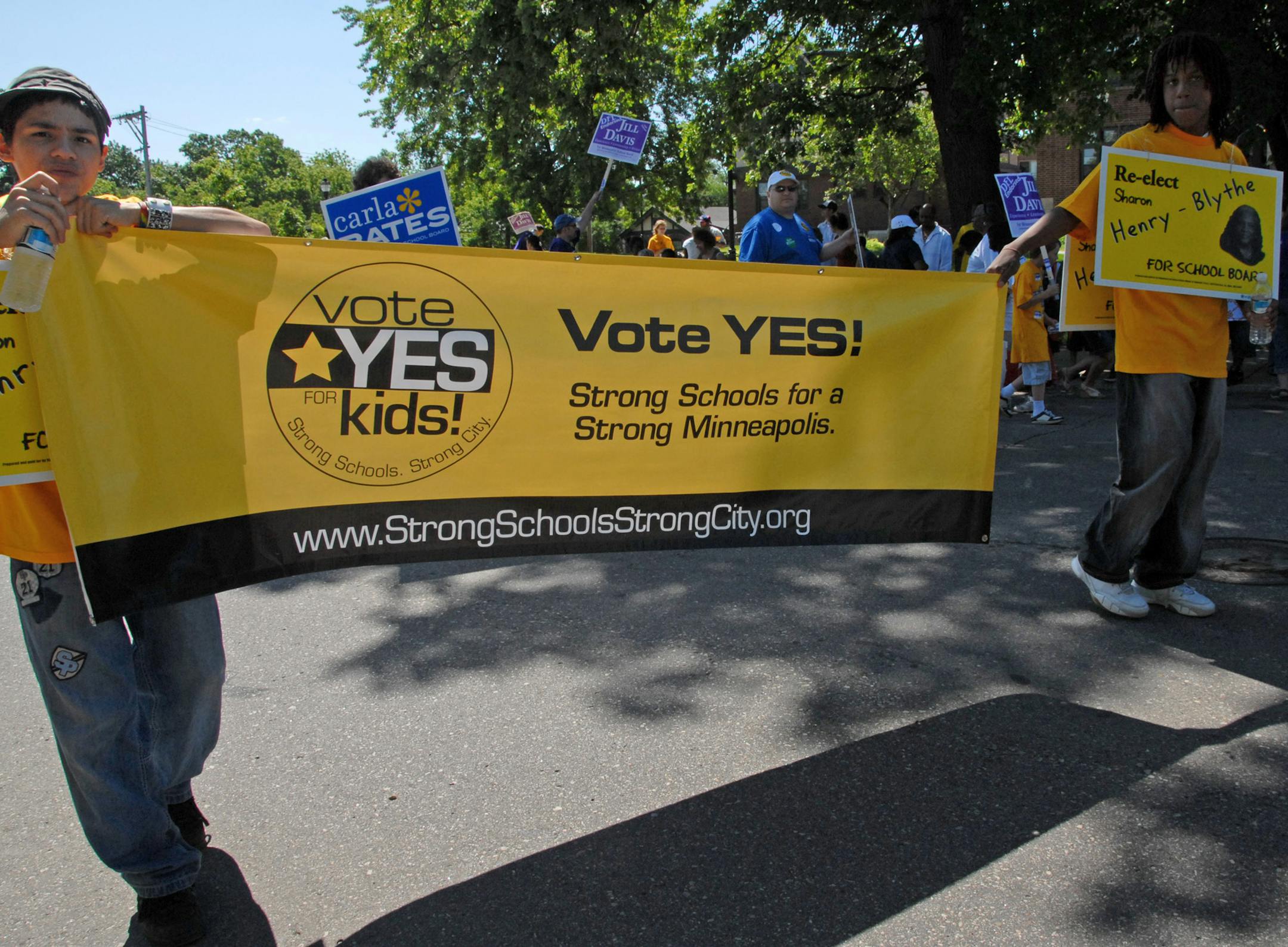 (Left to right) 15-year-old Stevie Yanez and 14-year-old Jahi (cq) Henry marched in the Juneteenth Day Parade with a banner for "Vote Yes! Strong Schools for a Strong Minneapolis".