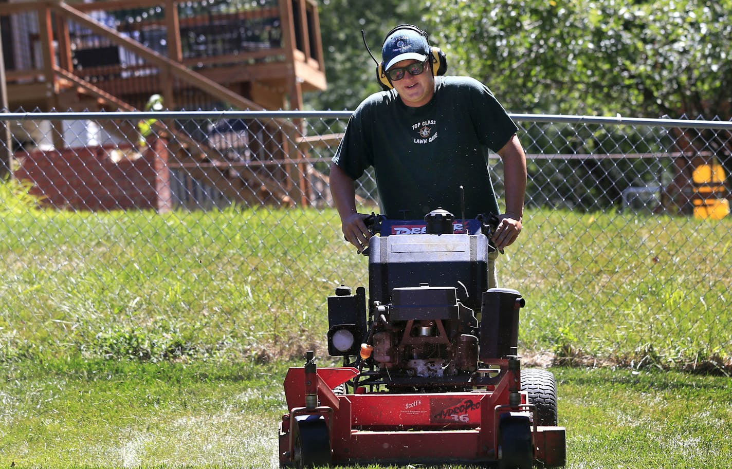 In this Monday, Aug. 22, 2016, photo, Jake Wilson, owner of Top Class Lawn Care, mows a lawn on a job in Kansas City, Mo. Wilson is on the fence about his 5-year-old company and whether he should add to his staff of three and buy another truck. Wilson is concerned that if he does expand, he won&#xed;t be giving his customers the kind of service he does now. (AP Photo/Orlin Wagner) ORG XMIT: MOOW301