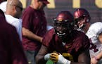 Minnesota Golden Gophers head coach P. J. Fleck talked with defensive tackle Micah Dew-Treadway (18) as he stretched with his teammates during practic