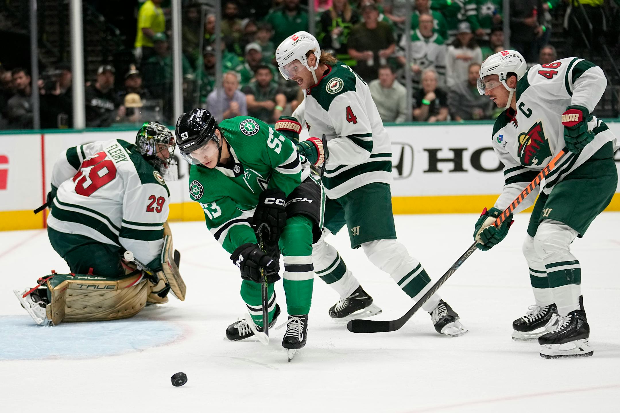 Dallas Stars center Wyatt Johnston (53) attempts take a shot as Minnesota Wild goaltender Marc-Andre Fleury (29), Jon Merrill (4) and Jared Spurgeon (46) defend against the pressure in the first period of Game 2.