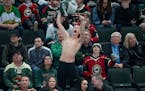 A fan waves their shirt about their head while pointing to the big screen in the third period Friday, April, 22, 2022 at Xcel Energy Center in St. Pau