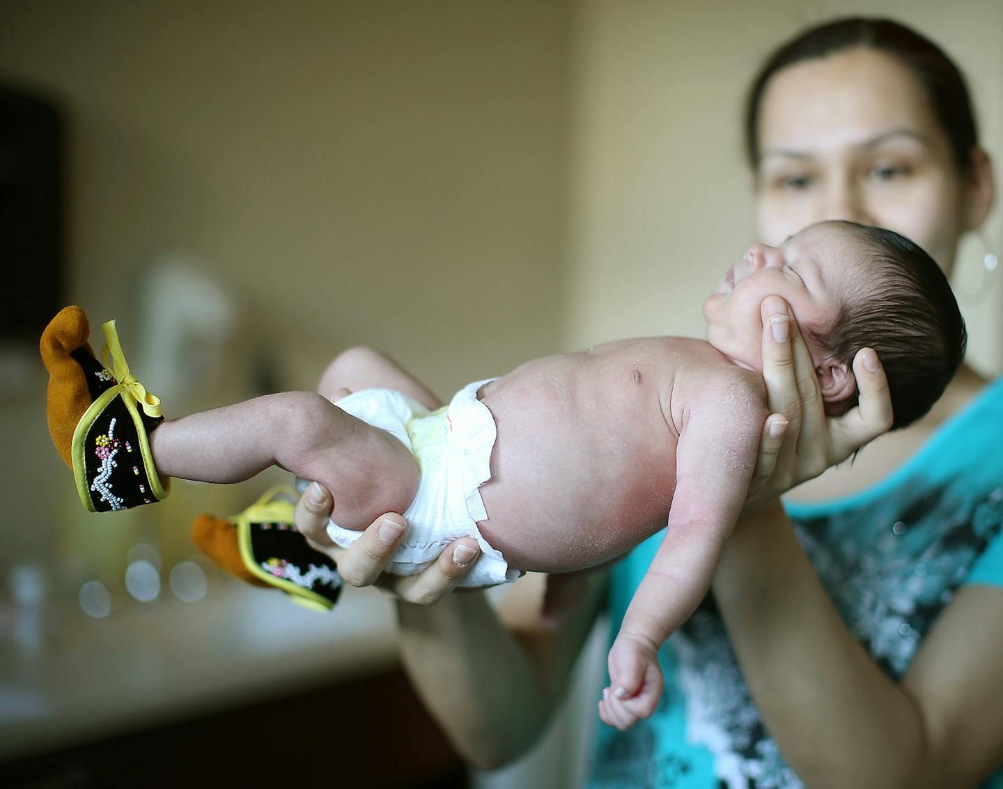 Cherise Browneagle held up her newborn Jacob Bellanger Jr., after he received his first pair of moccasins from the "Fist Gift," program while he was in the hospital, February 20, 2016 at Children's Hospital in Coon Rapids, MN. ] (ELIZABETH FLORES/STAR TRIBUNE) ELIZABETH FLORES &#x2022; eflores@startribune.com