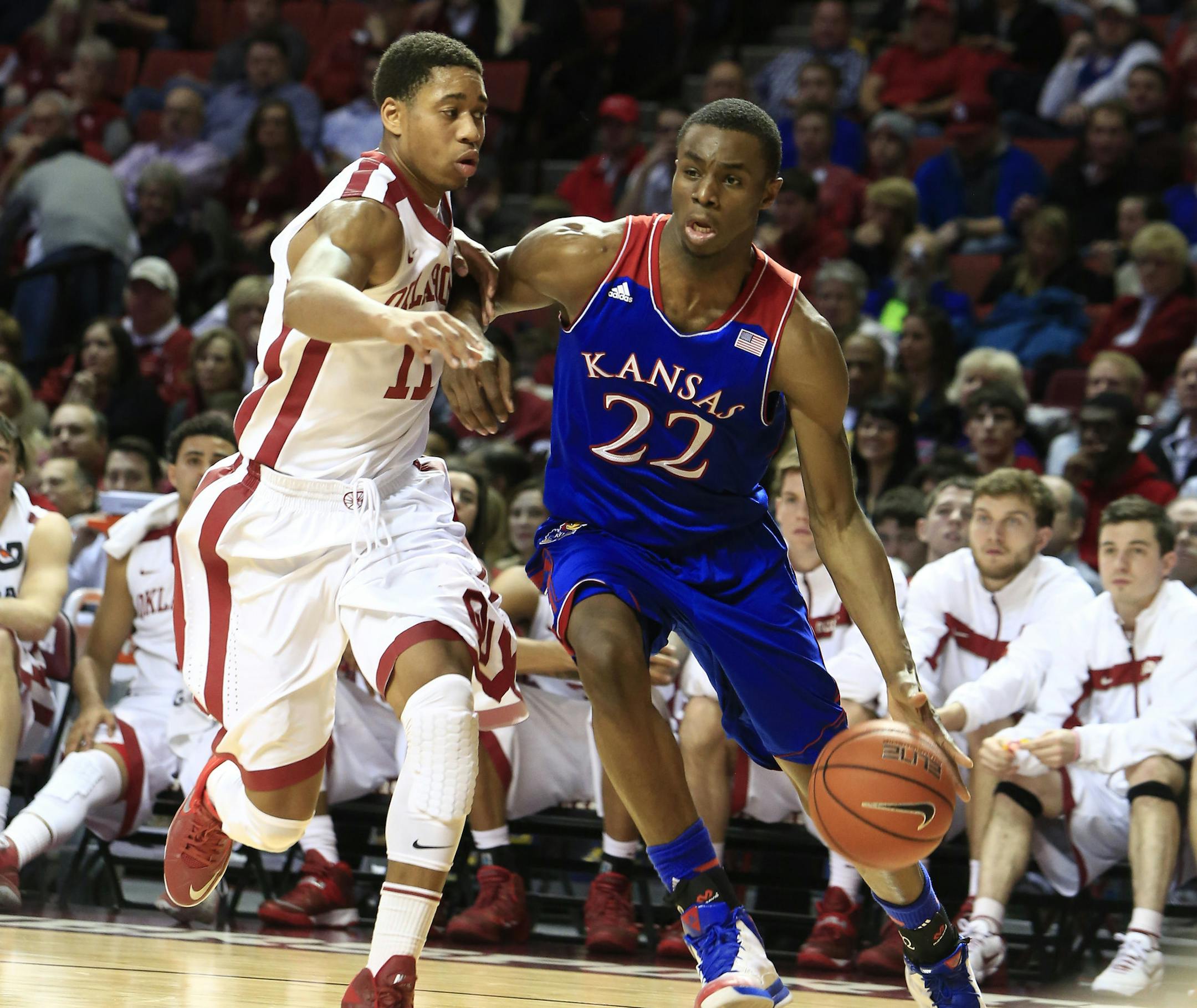 Kansas guard Andrew Wiggins, right, drives around Oklahoma guard Isaiah Cousins, left, during the first half of an NCAA college basketball game in Norman, Okla., Wednesday, Jan. 8, 2014. (AP Photo/Alonzo Adams)