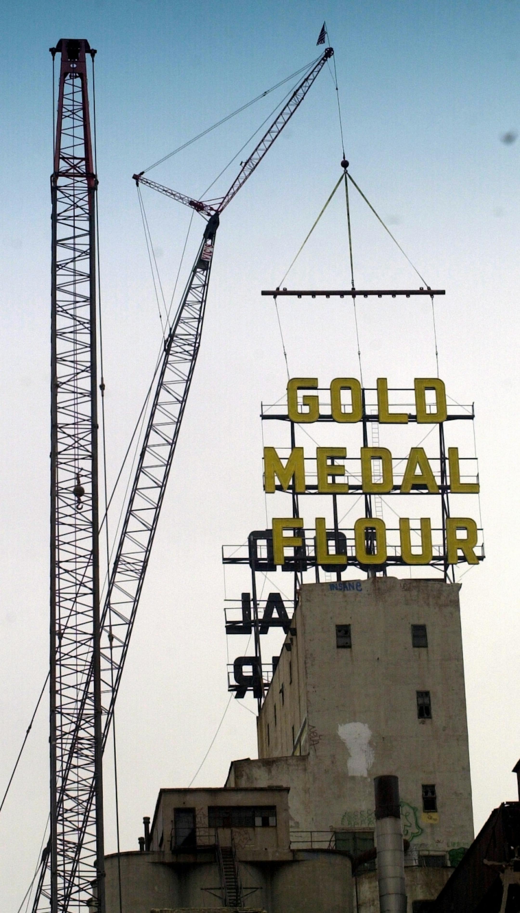 The twin Gold Medal Flour signs that were removed from atop the former General Mills complex on the Minneapolis riverfront for reconditioning are going back home. One sign was lifted Thursday morning, and the other is expected to went up this morning. The signs have been cleaned and repaired.
