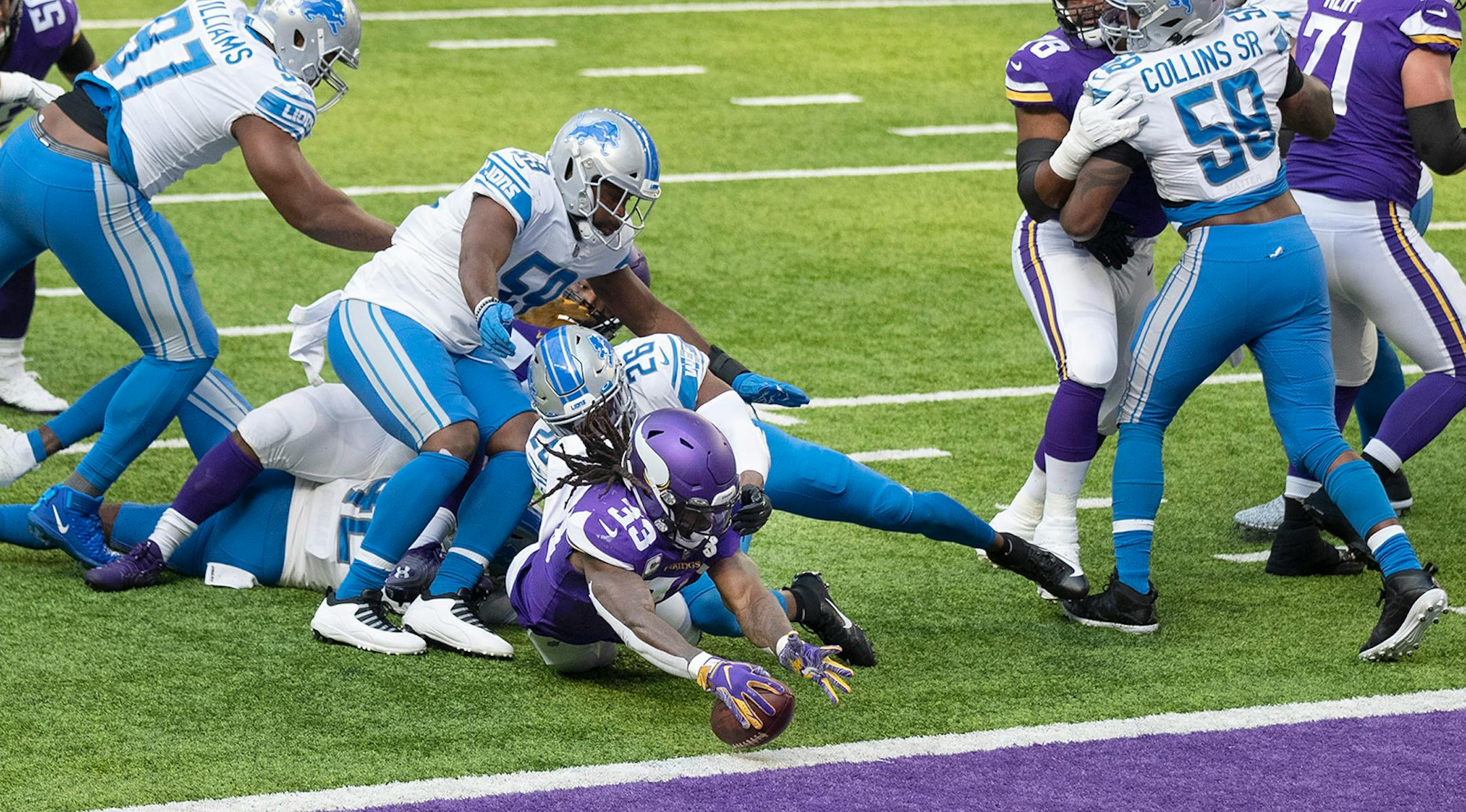 Minnesota Vikings running back Dalvin Cook (33) scored in the firs quarter over Detroit Lions strong safety Duron Harmon (26).
