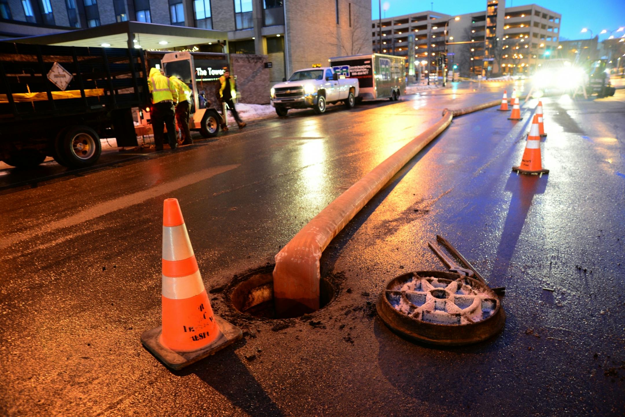 An area near the Hennepin Avenue Bridge remained closed Friday morning after a major water main break in downtown Minneapolis flooded streets and cut off water to a substantial swath of the city just before rush hour Thursday afternoon. Workers are trying to remove the backhoe that brooke the water main from a trench. A large crane has been put in position to hoist the backhoe. The water that flooded the streets near the Central Post Office and the Federal Reserve has completely receded . these