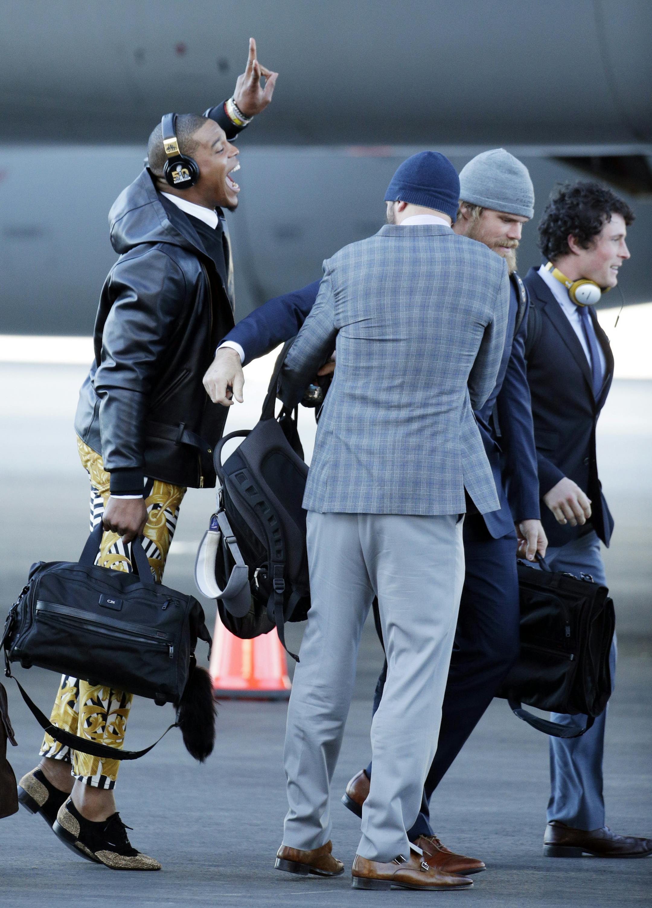 Carolina Panthers' Cam Newton jumps into a picture being taken of A.J. Klein, right to left, Greg Olsen and Derek Anderson after getting off the plane at the Mineta San Jose International Airport as they arrive for the NFL Super Bowl football game Sunday, Jan. 31, 2016, in San Jose, Calif. The Panthers play the Denver Broncos on Sunday, Feb. 7, 2015, in Super Bowl 50. (AP Photo/Charlie Riedel)