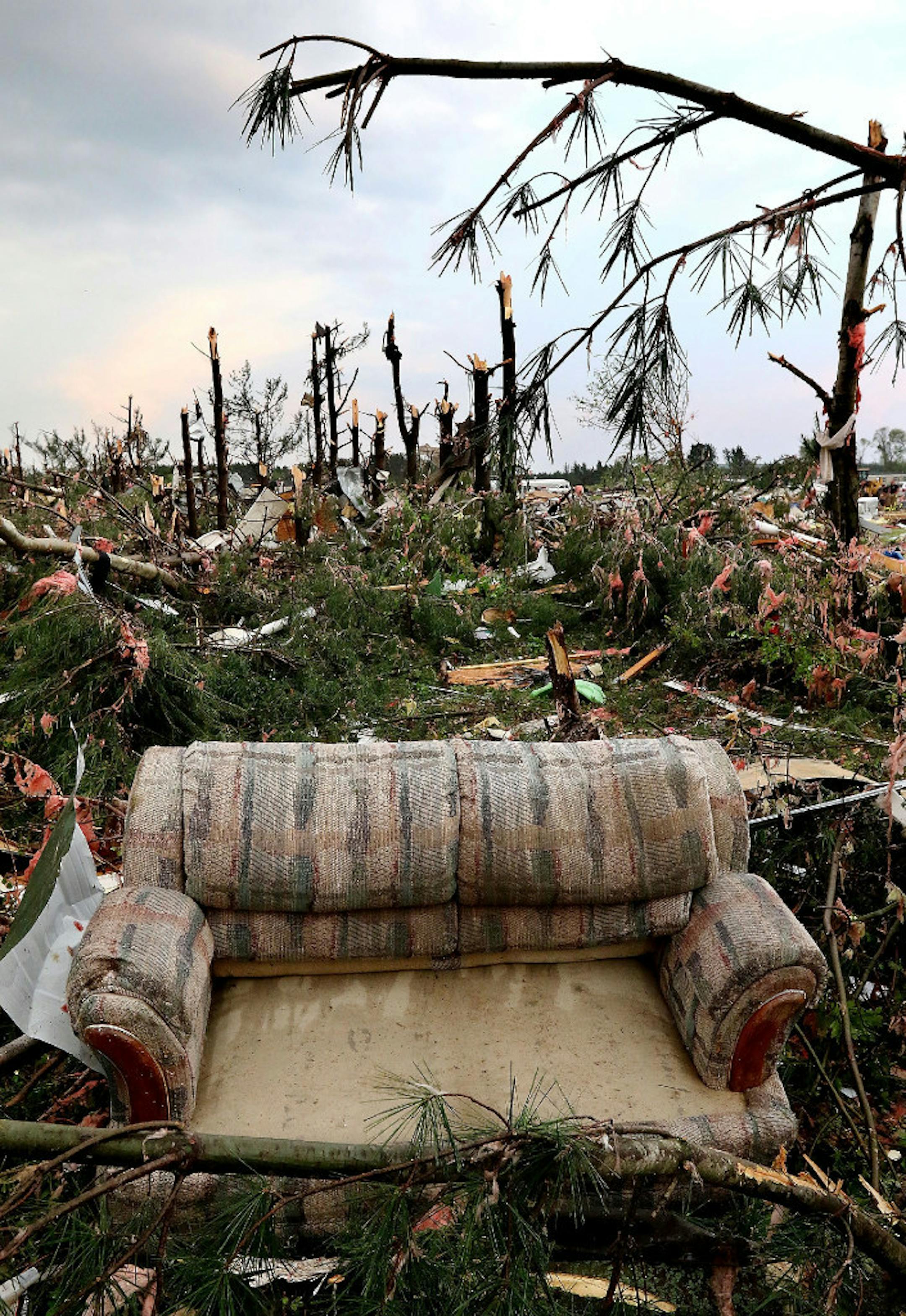 A sofa sits on damaged trees after a tornado ripped through Prairie Lake Estates trailer home park, just north of Chetek, Wis., Tuesday, May 16, 2017.