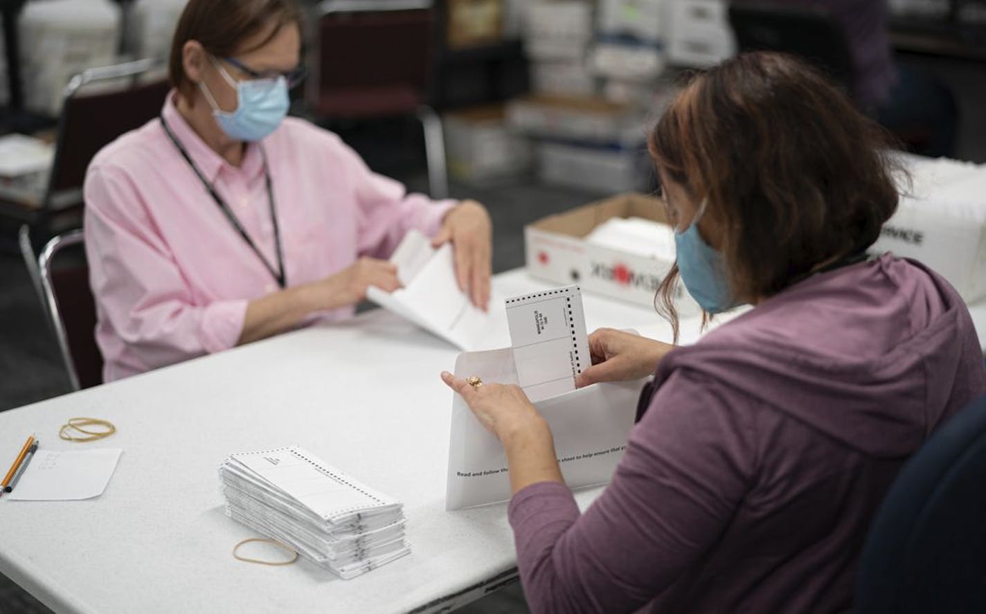 Lisa Finander, right, checks that each ballot has the voter's name on the ballot and mailing envelope and Laurie Mattila, left, checked that it was correct at Minneapolis Elections & Voter Services in Minneapolis. Minneapolis Elections & Voter Services has sent out over 85,000 ballots at a rate of 2500 per day. In 2016 they mailed a total of 3000.