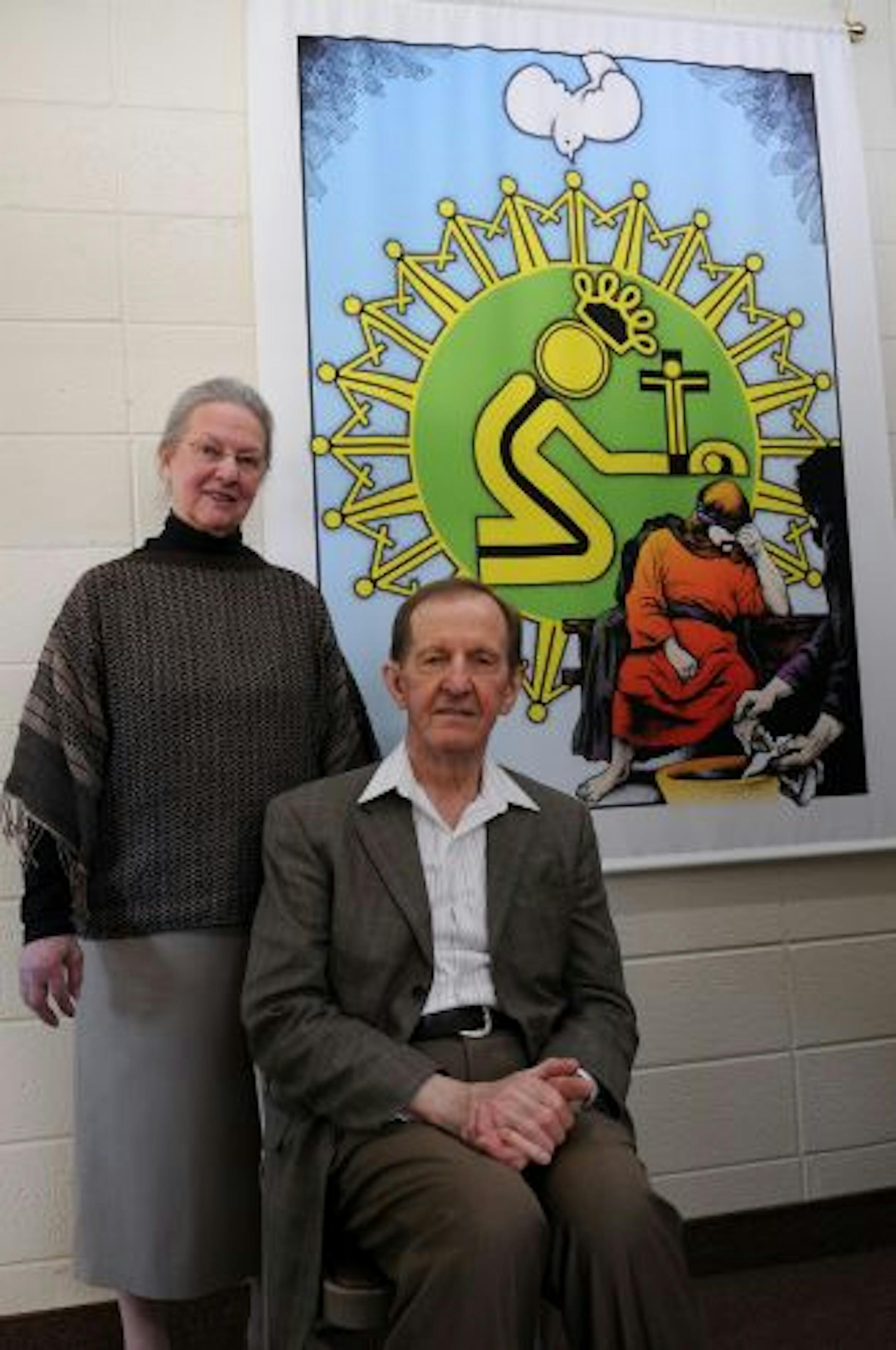 Chloris Wendt and the Rev. Harry Wendt stood next to a poster that is a signature image of Crossways International.