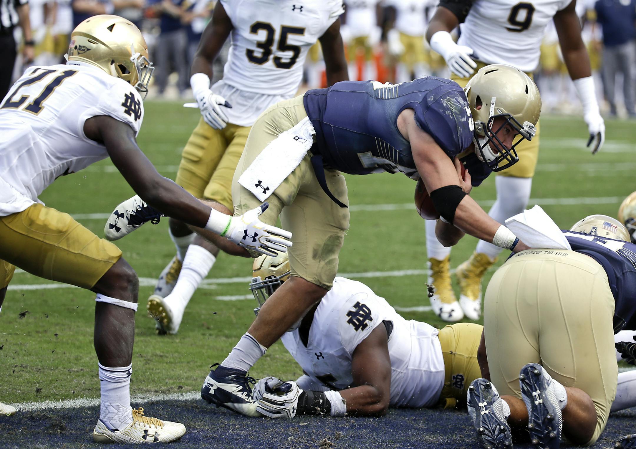 Navy quarterback Will Worth, center, runs past the Notre Dame safety Jalen Elliott (21) for a one-yard touchdown runduring the second half of an NCAA college football game Saturday, Nov. 5, 2016, in Jacksonville, Fla. Navy won 28-27. (AP Photo/John Raoux)