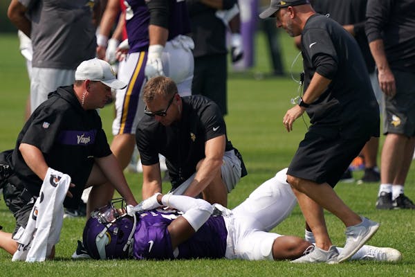 Vikings trainers attend to receiver Justin Jefferson at practice Friday. 