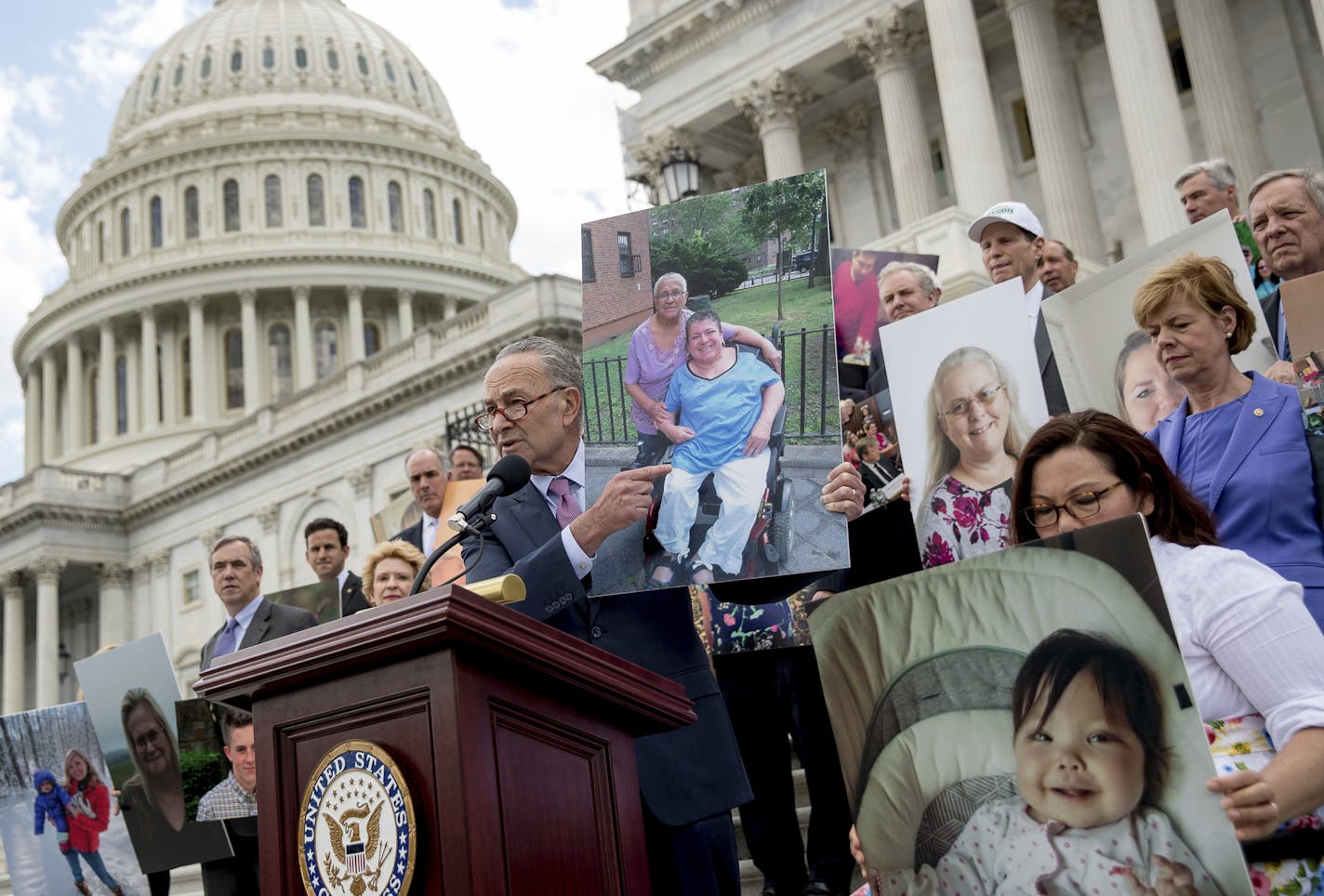 Senate Minority Leader Sen. Chuck Schumer and other Democratic senators held up photos of constituents who would be hurt by the proposed Republican Senate health care bill while outside the U.S. Capitol on Tuesday.