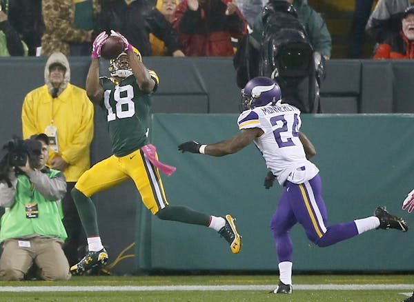 Green Bay Packers wide receiver Randall Cobb (18) caught a pass for a touchdown in the first quarter despite defensive pressure by Minnesota Vikings c