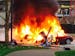 In this photo provided by KOMO-TV, a car burns at the scene of a helicopter crash outside the KOMO-TV studios near the space needle in Seattle on Tues