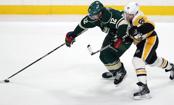 Wild player Eric Staal(12) tries to make a breakaway while Phil Kessel(81) holds on.