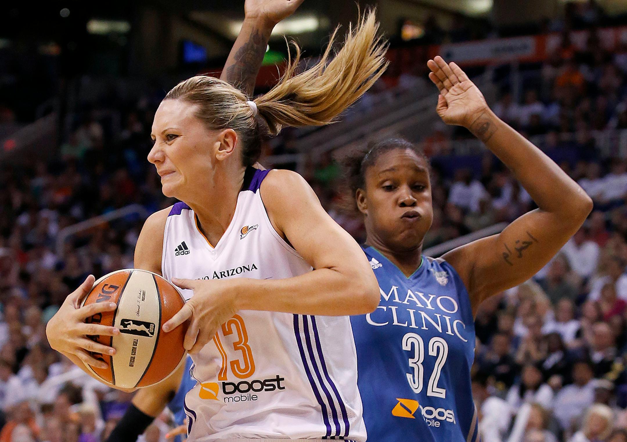 Phoenix Mercury's Penny Taylor (13), of Australia, pulls down a rebound in front of Minnesota Lynx's Rebekkah Brunson (32) during the first half of Game 3 in the WNBA Western Conference basketball finals Tuesday, Sept. 2, 2014, in Phoenix. (AP Photo/Ross D. Franklin)