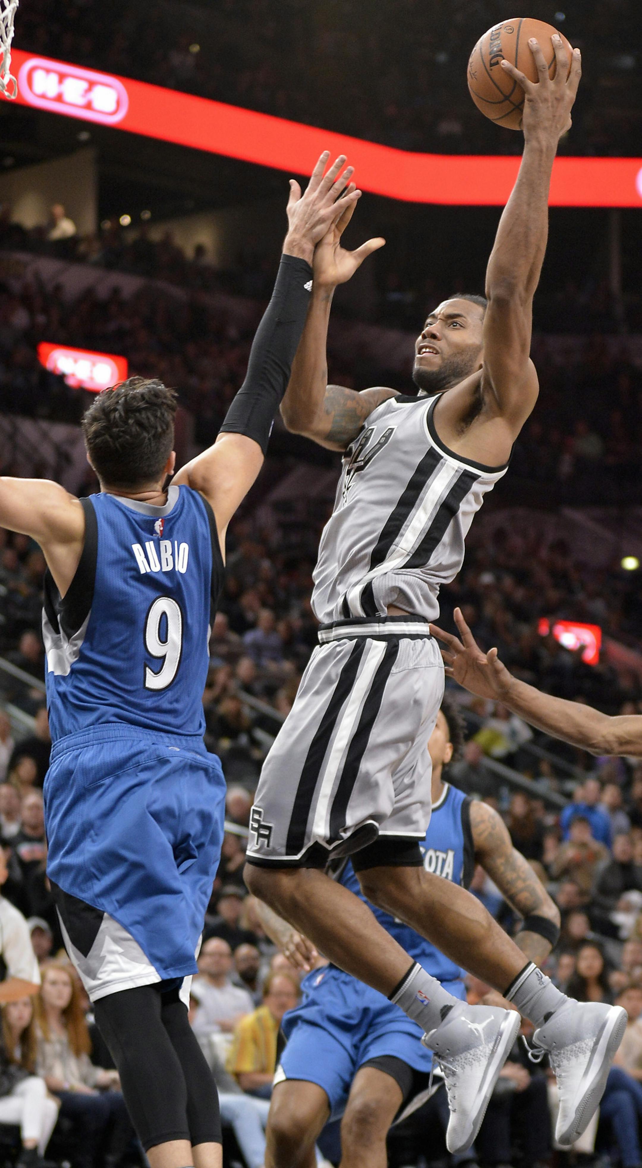 San Antonio Spurs forward Kawhi Leonard, right, shoots against Minnesota Timberwolves guard Ricky Rubio, of Spain, during the second half of an NBA basketball game, Saturday, March 4, 2017, in San Antonio. San Antonio won 97-90. (AP Photo/Darren Abate)