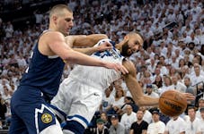 Wolves center Rudy Gobert (27) is defended by Nuggets counterpart Nikola Jokic (15) in the first quarter Sunday night.