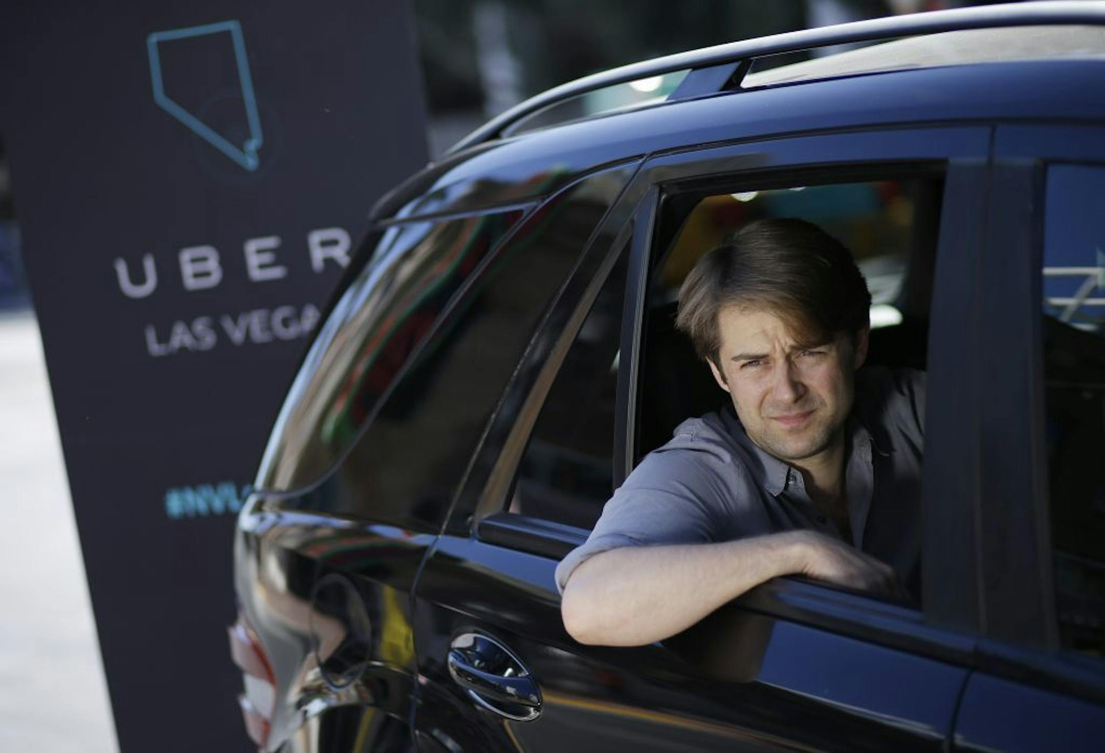 Uber West Coast Regional Manager William Barnes sits in the back of a car during a photo shoot Friday, Oct. 24, 2014, in Las Vegas. The ride sharing company has begun operations in Nevada.