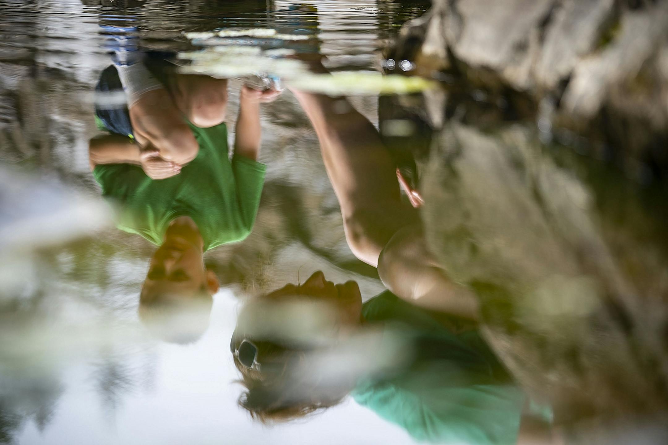 (Left) Brock Anderson (6) and his mother, Alissa, were reflected in the water as they searched for a frog they were trying to catch at Jay Cooke State Park on Wednesday.