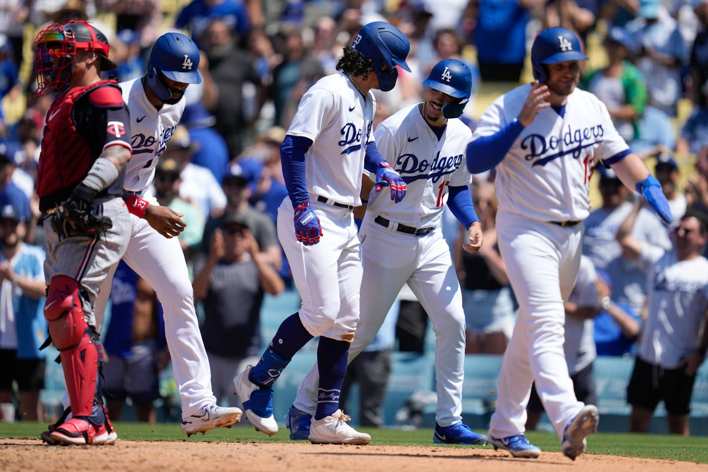 Los Angeles Dodgers' James Outman, center, Jason Hayward, second from left, Miguel Vargas (17), and Max Muncy (13) after they all scored off of a grand slam home run hit by Outman during the seventh inning of a baseball game against the Minnesota Twins in Los Angeles, Wednesday, May 17, 2023. (AP Photo/Ashley Landis)