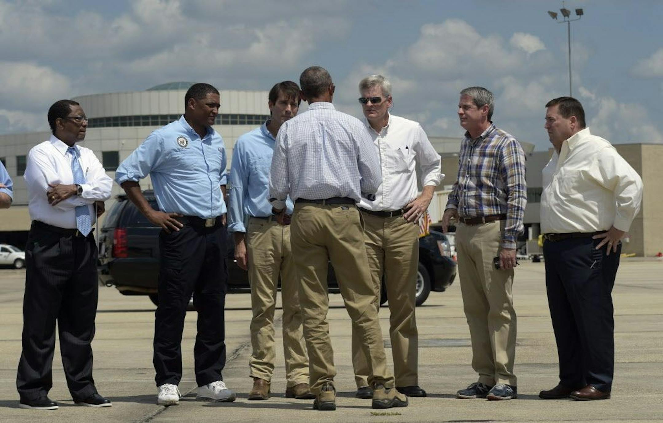President Barack Obama talks on the tarmac after arriving on Air Force One at Baton Rouge Metropolitan Airport in Baton Rouge, La., Tuesday, Aug. 23, 2016. Obama is traveling to the area to survey the flood damage. From left are, Baton Rouge, La. Mayor Kip Holden, Rep. Cedric Richmond, D-La., Rep. Garret Graves, R-La., Sen. Bill Cassidy, R-La., Sen. David Vitter, R-La., and Louisiana Lt. Gov. Billy Nungesser.