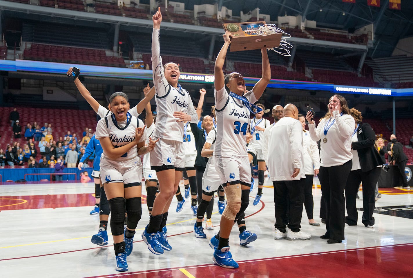 Hopkins players celebrate after defeating St. Michael-Albertville 72-56 in the MSHSL girls' basketball 4A state championship Saturday, March 19, 2022 at Williams Arena in Minneapolis, Minn. ]