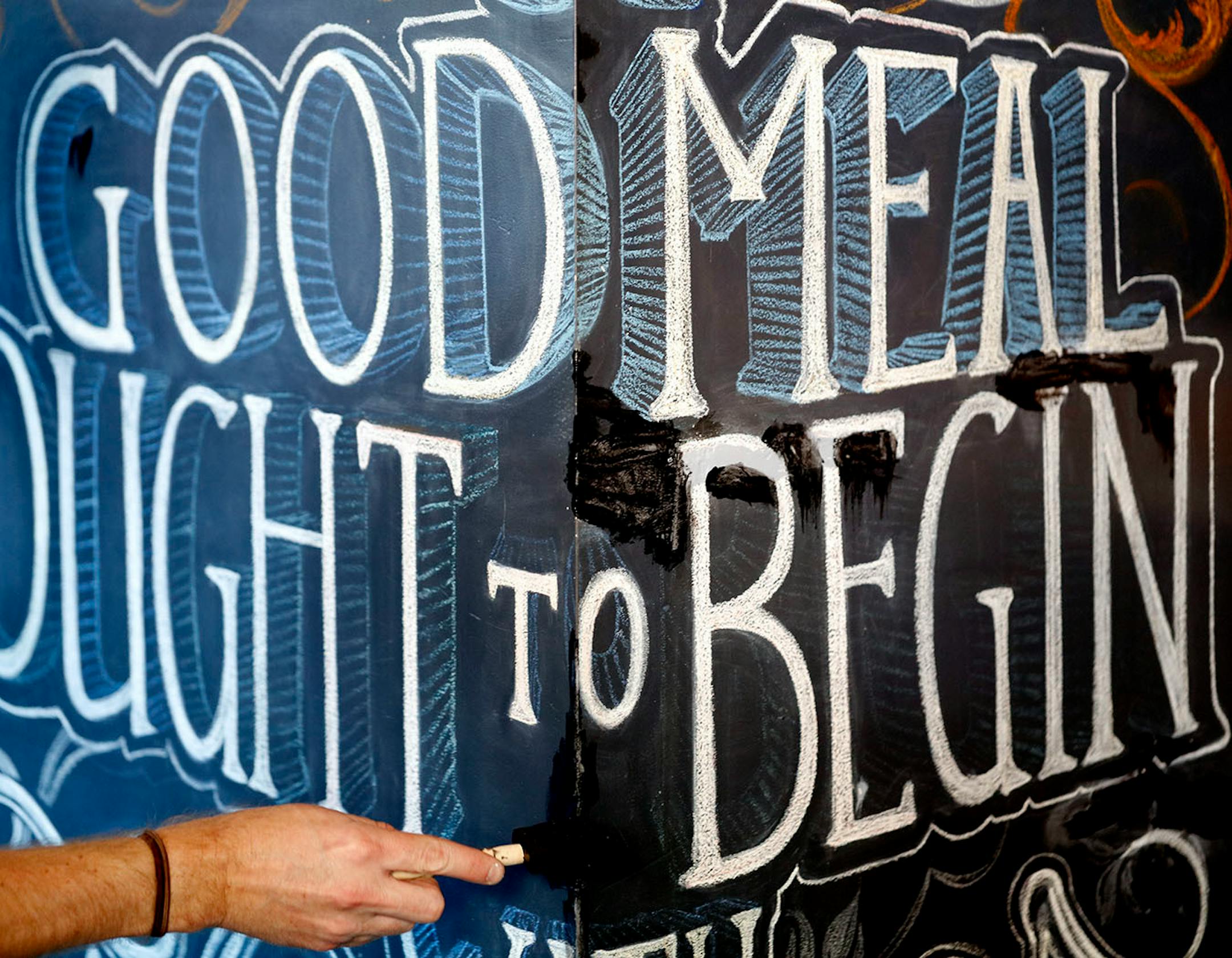 Adam Dennis works on his murals at Coup d'Etat restaurant in Uptown. Dennis' work include Smack Shack and the Pourhouse and is done with chalk and spray paint.