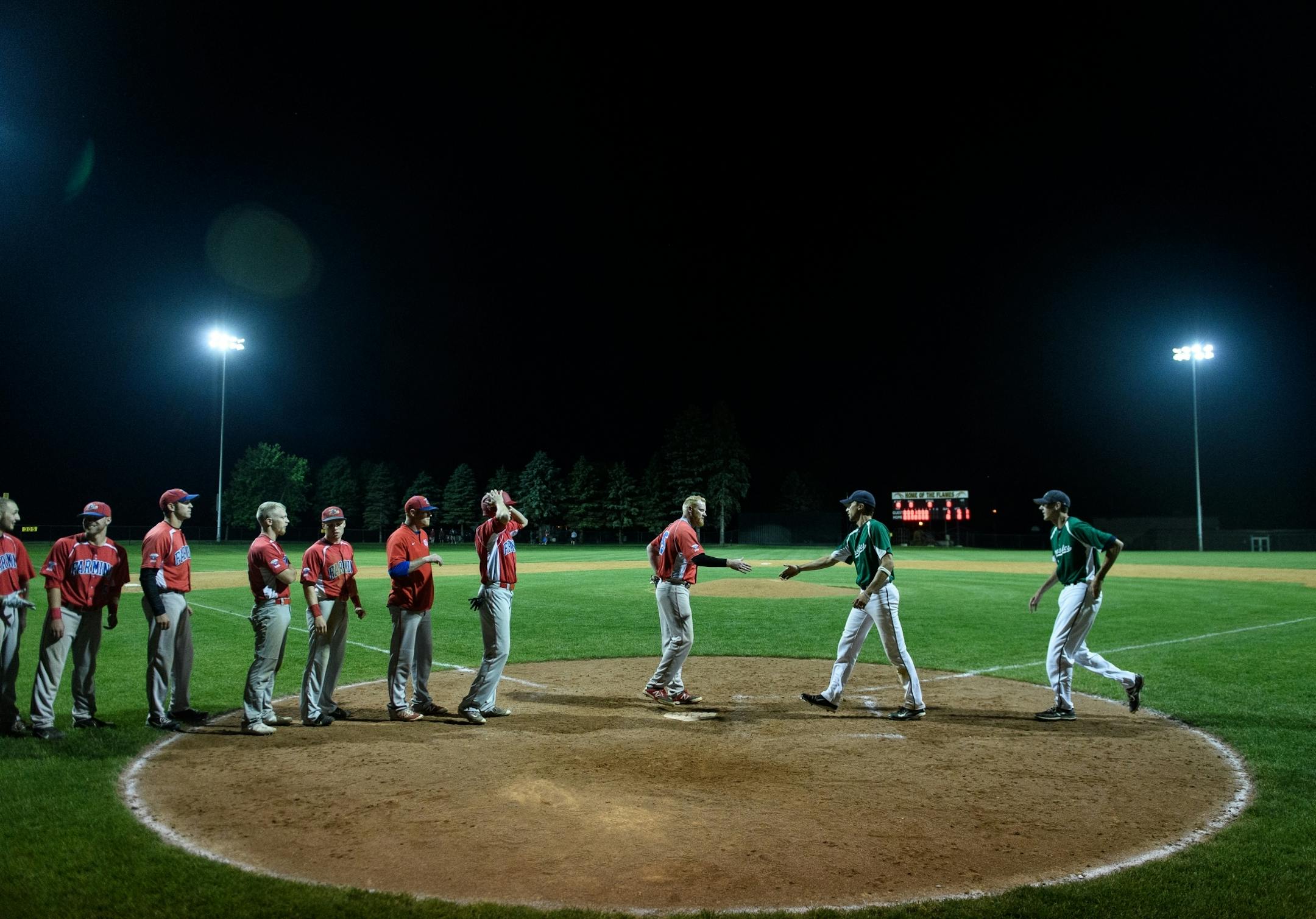 Baseball players from the Farming Flames, left, and the Sartell Muskies shook hands following the Muskies' 1-0 victory over Farming on Friday, June 23, 2017 during the Farming Invitational Tournament in Farming, Minn .