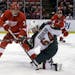 Detroit Red Wings defenseman Kent Huskins (3) and Minnesota Wild center Mikael Granlund (64), battle for the puck during the first period of an NHL ho