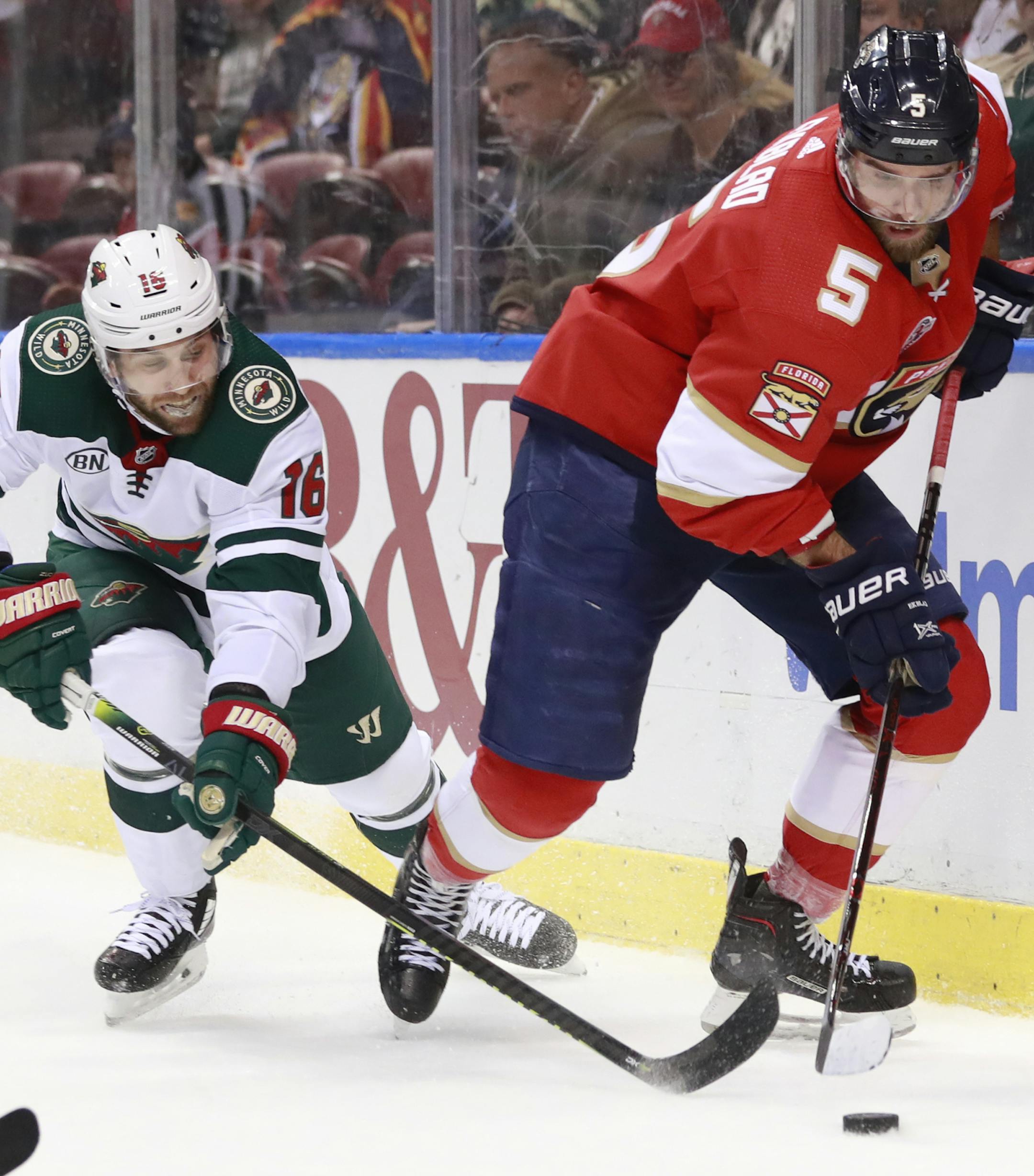 Minnesota Wild left wing Jason Zucker (16) and Florida Panthers defenseman Aaron Ekblad (5) battle for the puck during the first period of an NHL hockey game, Friday, March 8, 2019, in Sunrise, Fla. (AP Photo/Wilfredo Lee)
