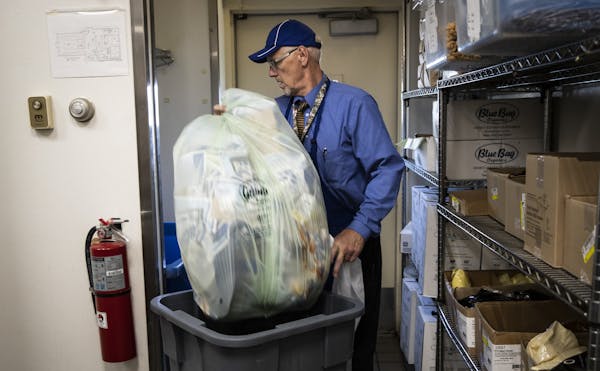 Owner David Rech threw a bag of composted food, napkins and trays to a bin for it to be later collected at Culver's in Plymouth, Minn., on Friday, Oct