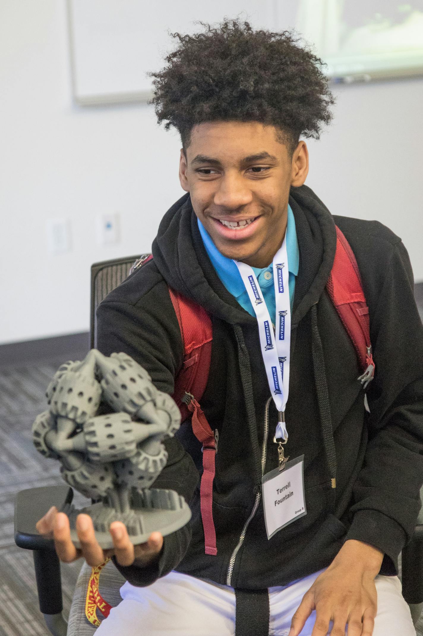 Terrell Fountain holds a 3-D printed gear mechanism at Stratasys as part of a partnership with the Delta Sigma Theta sorority.