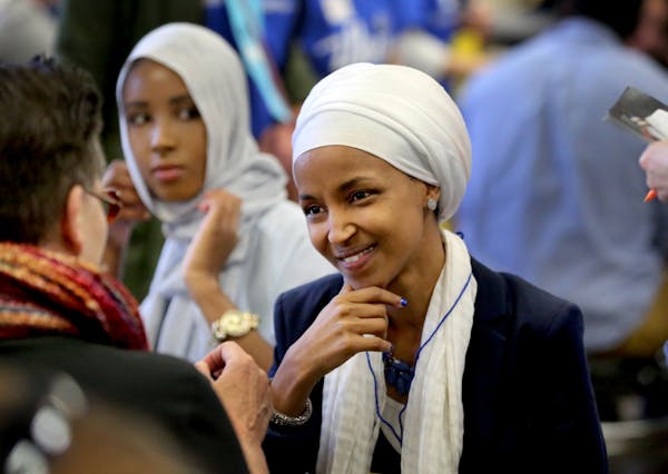 Ilhan Omar spoke with a delegate at Northeast Middle School during the DFL endorsing convention Saturday, April 9, 2016, in Minneapolis.