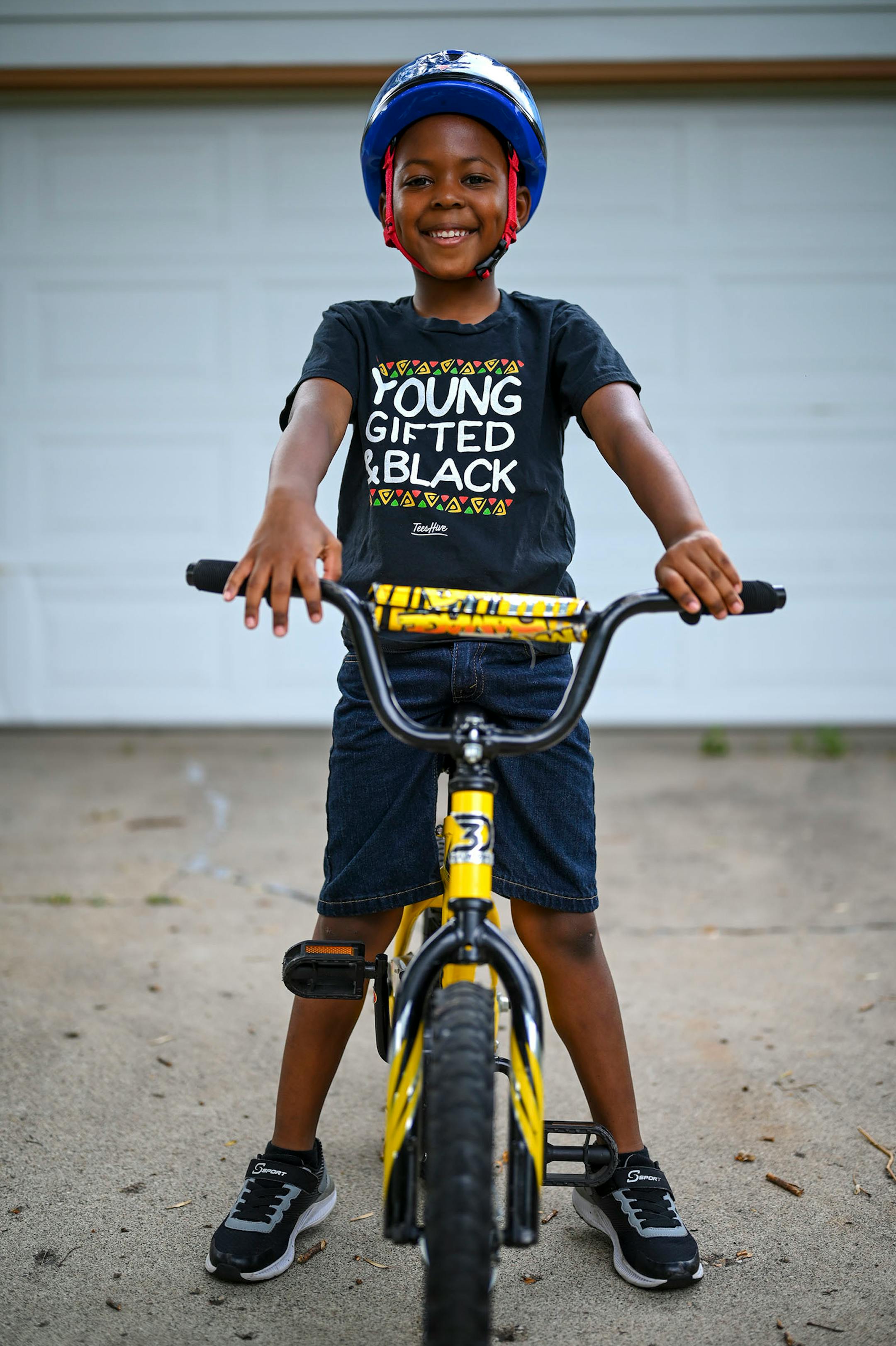 D.J. Buford, 6, stood for a portrait with his bike outside his Bloomington home Thursday afternoon. "I don't get to go to birthday parties, or school" said Buford, who recently had to be pulled from his new daycare after possible COVID-19 exposure shut it down for two weeks. Buford misses school more than anything. "It's like peanut butter without jelly," said D.J., "the jelly is the school and I am the peanut butter and the peanut butter doesn't get to go to the jelly and I don't get to to go s