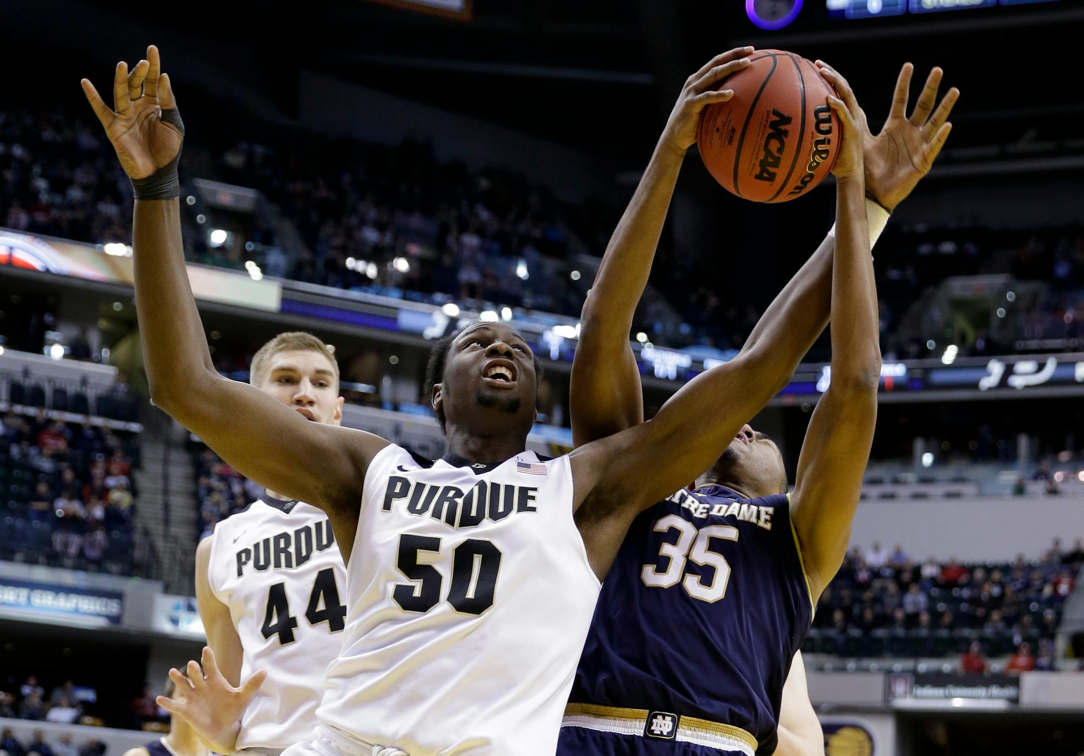 Purdue forward Caleb Swanigan (50) and Notre Dame forward Bonzie Colson (35) get entangled as they go for a rebound during the first half of an NCAA college basketball game in Indianapolis, Saturday, Dec. 17, 2016. (AP Photo/Michael Conroy)