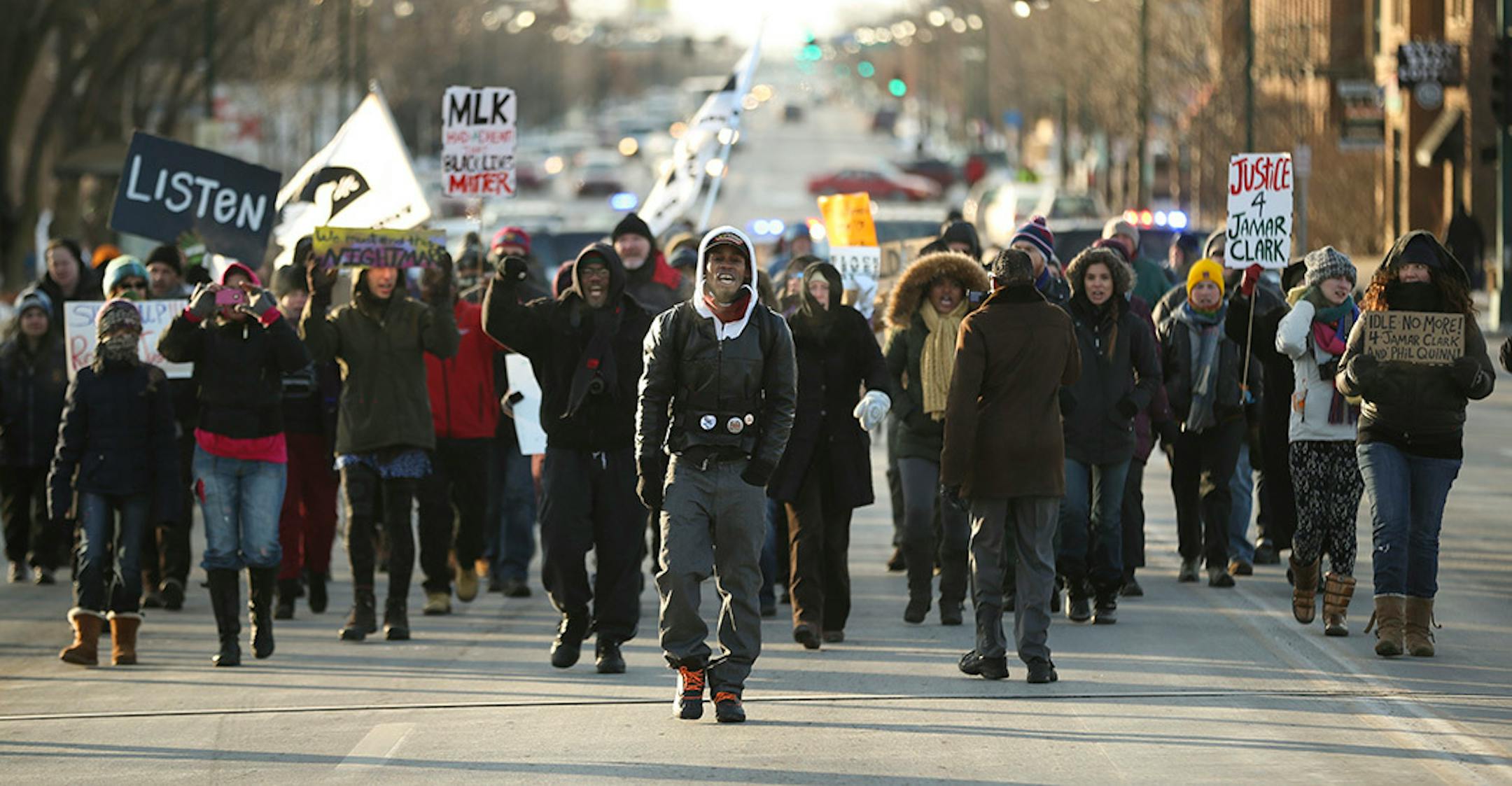 Alexander Clark, center, a cousin of Jamar Clark, led demonstrators as they marched on the Lake St. bridge to meet their St. Paul counterparts on Monday.