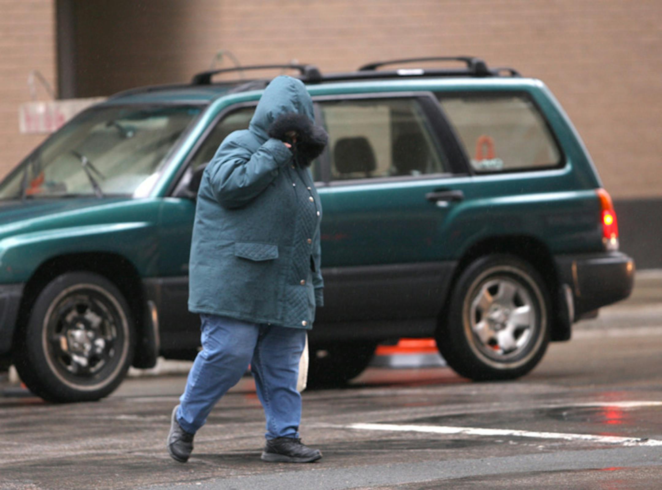 Kathleen Murschel of Brooklyn Center was bundled up to battle the driving rain as she crossed the street in downtown Minneapolis on Thursday afternoon.